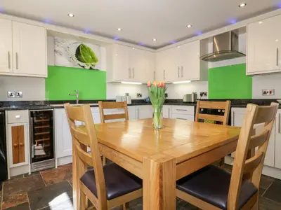 a kitchen with a wooden table and chairs at The Old Smithy in Saint Columb Major