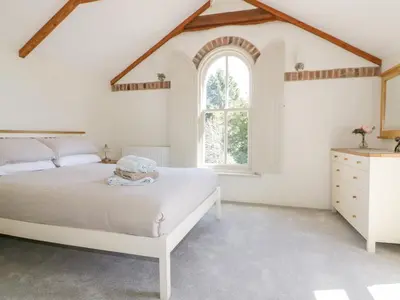 a white bedroom with a bed and a window at The Old Smithy in Saint Columb Major