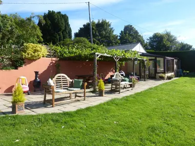 a patio with chairs and a table in a yard at The Old Granary in Launceston