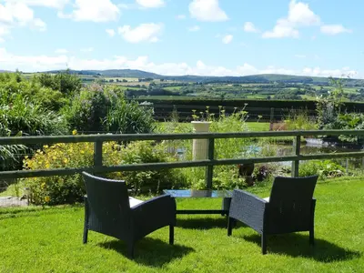 two chairs and a table on a lawn with a view at The Old Granary in Launceston