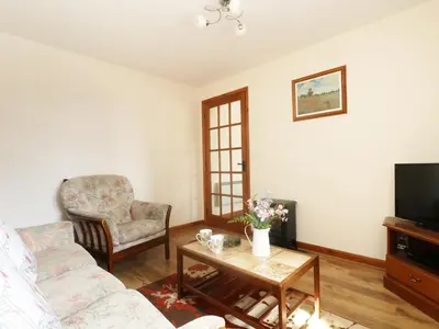 a living room with a couch and a table and a tv at The Old Granary in Launceston