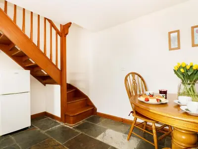 a dining room with a table and a staircase at The Shippon in Launceston