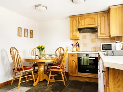 a kitchen with a table and chairs in a kitchen at The Shippon in Launceston