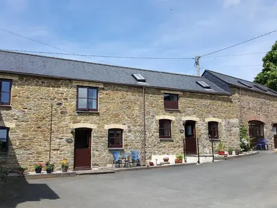 an old stone building with windows and doors at The Shippon in Launceston