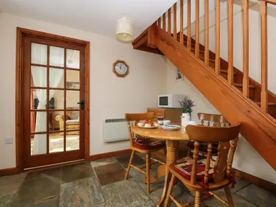 a dining room with a table and a staircase at The Wagon House in Launceston