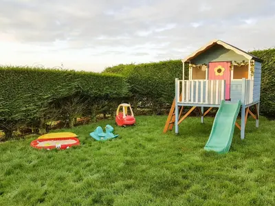 a childs play area with a house and a playground at The Wagon House in Launceston