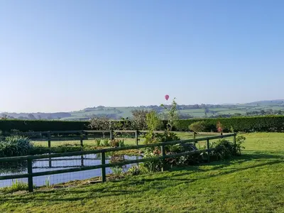 a fence next to a pond in a field at The Wagon House in Launceston
