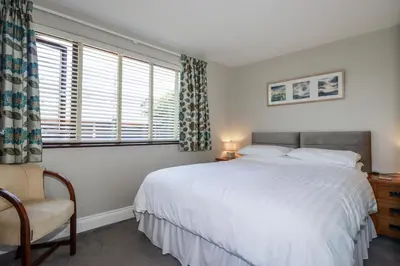 a bedroom with a large white bed and a chair at Jenny Wren in Par