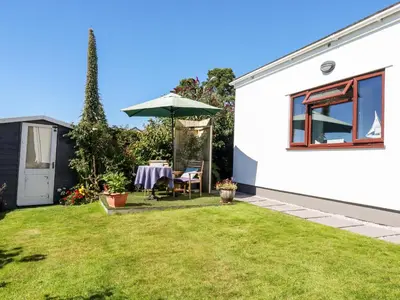 a garden with a table and an umbrella at Jenny Wren in Par