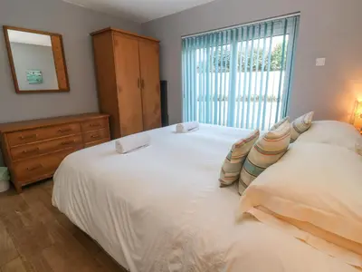 a bedroom with two white beds and a window at Beachcombers in Newquay