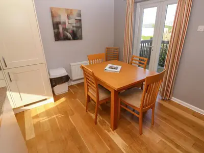 a dining room with a wooden table and chairs at Beachcombers in Newquay