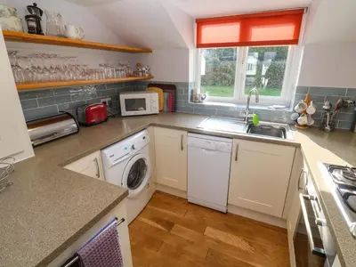 a kitchen with a sink and a washing machine at Beachcombers in Newquay