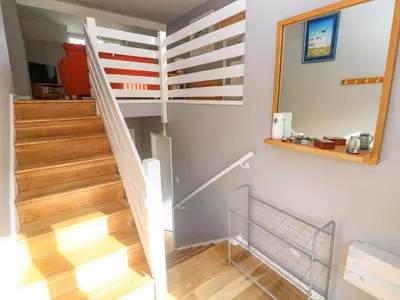 a staircase in a house with a mirror and a stair case at Beachcombers in Newquay