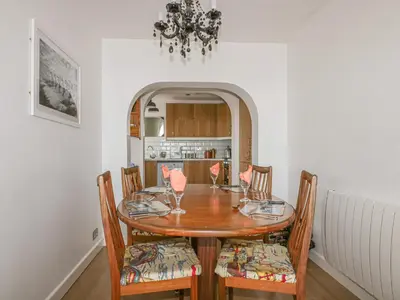 a dining room with a wooden table and chairs at Spindrift in Newquay