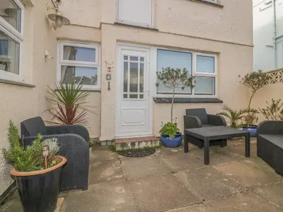 a patio with furniture and plants in front of a house at Spindrift in Newquay
