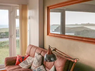 a living room with a couch and a large window at Spindrift in Newquay