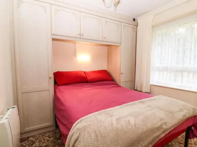 a bedroom with a bed with a red blanket at Peacehaven in Liskeard