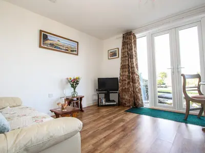 a living room with a couch and a tv at Sunset Cottage in Tintagel