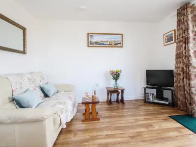 a living room with a couch and a tv at Sunset Cottage in Tintagel