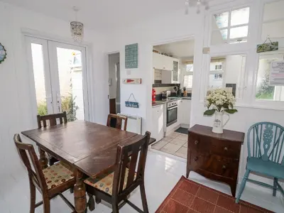 a kitchen and dining room with a wooden table and chairs at Driftwood in Wadebridge