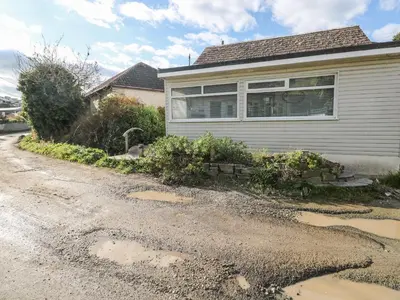 a house with a puddle of water on a driveway at Driftwood in Wadebridge