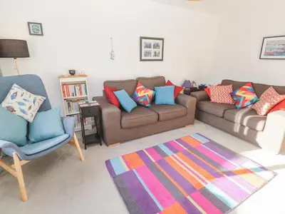 a living room with two couches and a colorful rug at Kernow Cottage in Helston