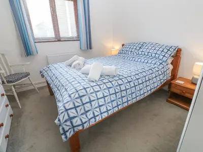 a bedroom with a bed with two pillows on it at Kernow Cottage in Helston