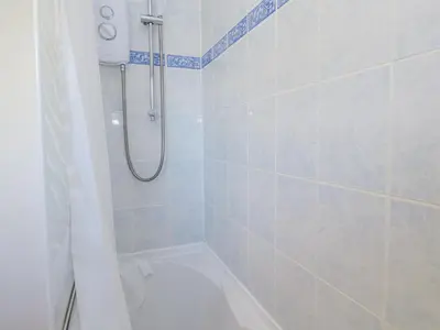 a bathroom with a shower with a tub and a toilet at Kernow Cottage in Helston