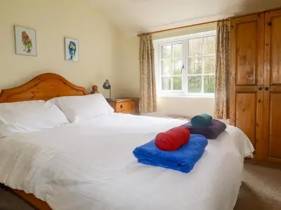 a bedroom with a bed with two pillows on it at Honeysuckle in Gorran Haven