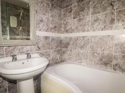 a bathroom with a sink and a toilet and a bath tub at Honeysuckle in Gorran Haven