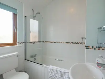 a bathroom with a shower and a toilet and a sink at High Tide in Wadebridge