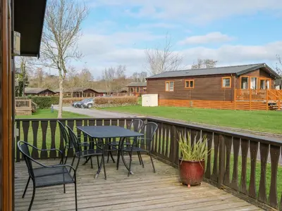 a deck with a table and chairs and a cabin at High Tide in Wadebridge