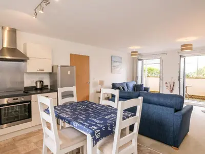 a kitchen and living room with a blue couch and a table at Stone's Throw in Charlestown