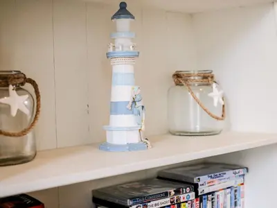a shelf with a lighthouse toy and dvds at Stone's Throw in Charlestown