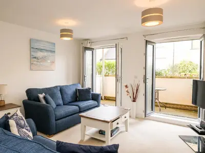 a living room with a blue couch and a table at Stone's Throw in Charlestown