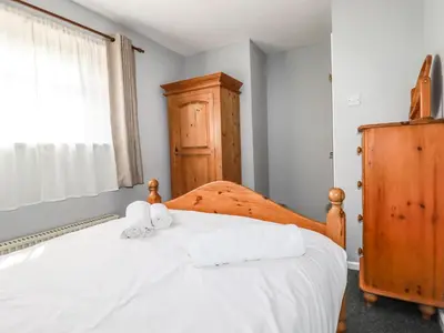 a bedroom with a bed with two towels on it at Stable Cottage in Newquay
