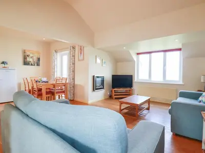 a living room with a blue couch and a table at The Beach House in Newquay