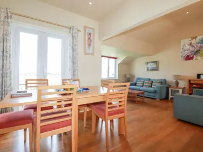 a dining room and living room with a table and chairs at The Beach House in Newquay