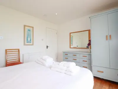 a bedroom with a white bed with towels on it at The Beach House in Newquay