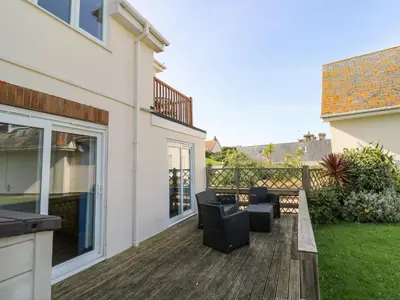 a deck with a couch and chairs on a house at The Beach House in Newquay