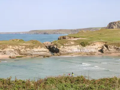 a body of water with people on the beach at The Beach House in Newquay