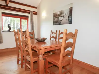 a dining room with a wooden table and chairs at Kingfisher Barn in Liskeard