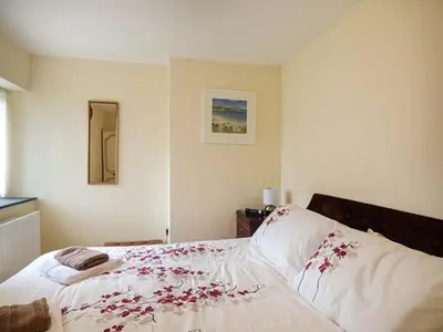 a bedroom with a bed with red flowers on it at Shepherds Rest in Warbstow
