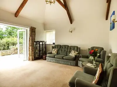 a living room with couches and a living room with a window at Shepherds Rest in Warbstow