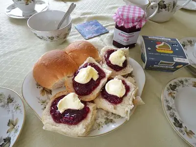 a plate of food with jam and buns on a table at Shepherds Rest in Warbstow