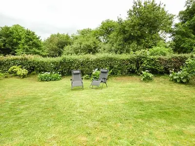 two chairs sitting in the grass in a yard at Shepherds Rest in Warbstow