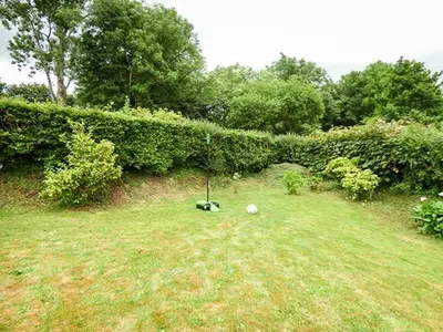 a yard with a hedge and a field with a ball at Shepherds Rest in Warbstow