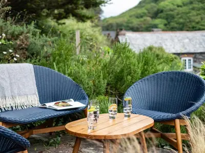two chairs and a table with glasses on it at Cobble Cottage in Boscastle