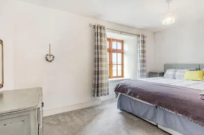 a bedroom with a bed and a window at Victoria Cottage in Newquay