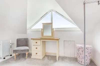 a dressing table with a mirror and a chair at Victoria Cottage in Newquay